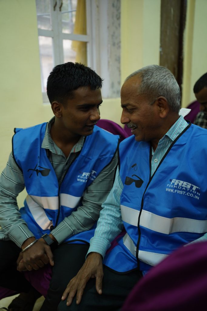 Two people in blue FRST reflective jackets in conversation.