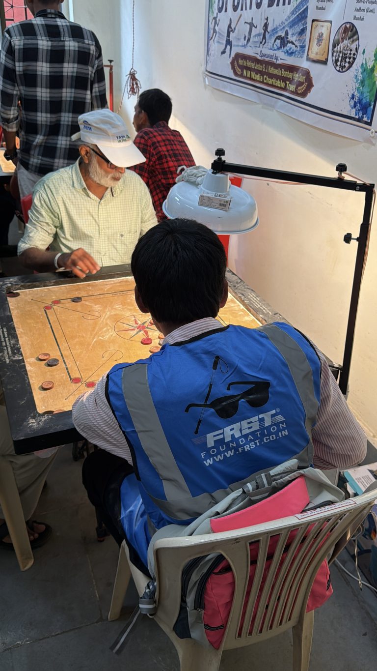 A player wearing a blue reflective jacket plays carrom at the National Sports Club of the Blind.