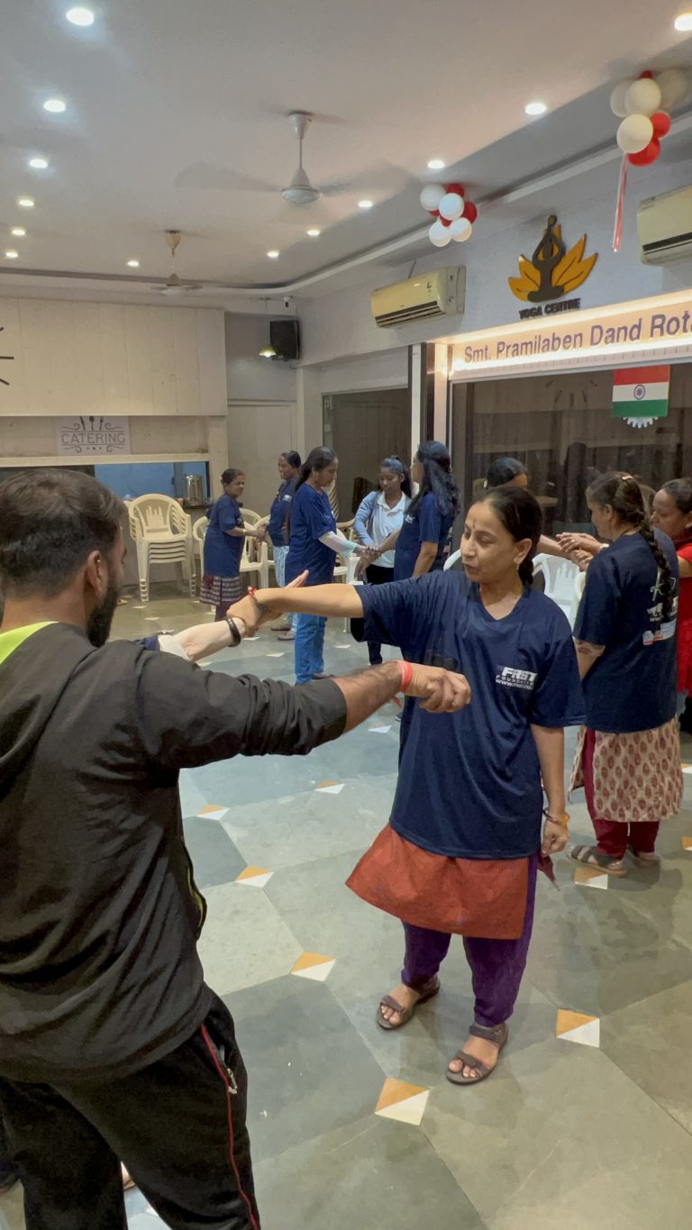 Participants practise a wrist-release movement together during a self-defence session.