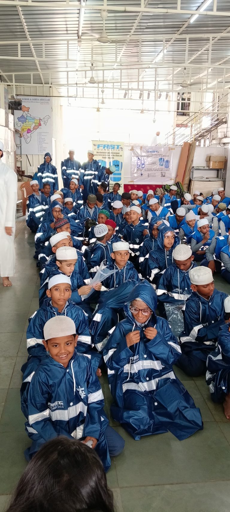 Students wearing dark blue reflective raincoats gather at Vision School in Pune.
