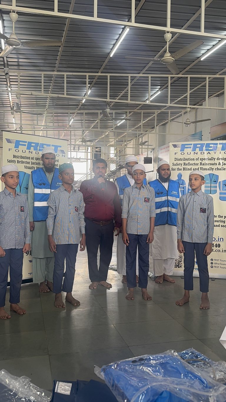 Children and staff stand beside FRST safety-gear banners at Vision School in Pune.